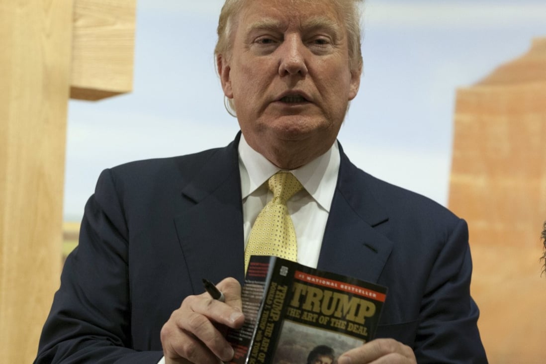 Then-presidential candidate Donald Trump holds a copy of his book, The Art of the Deal in June 2015. Publishing industry staff are conflicted over the possibility that he will publish a memoir after leaving The White House. Photo: Reuters