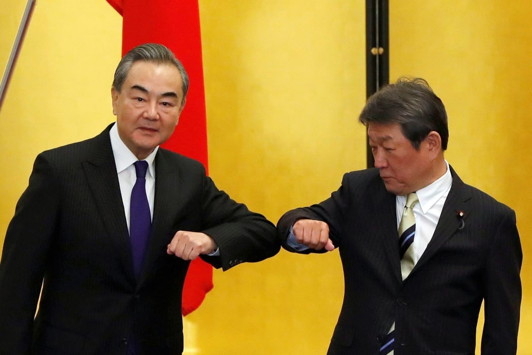 China’s Foreign Minister Wang Yi (left) and his Japanese counterpart Toshimitsu Motegi bump elbows during their meeting in Tokyo. Photo: Reuters