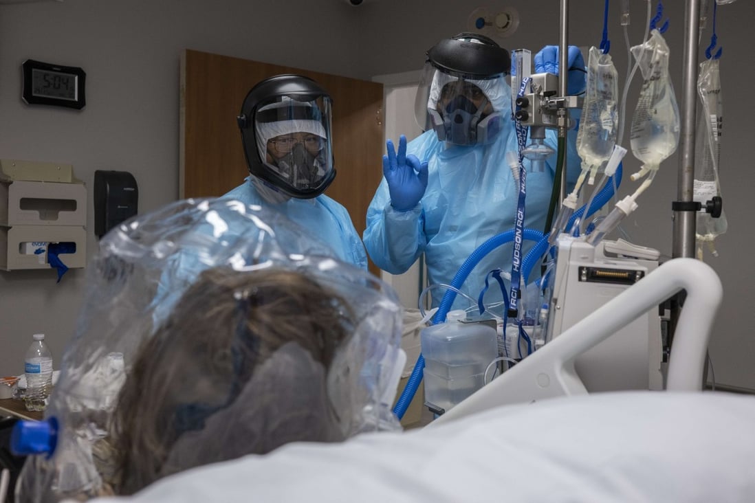 Medical staffers check on the comfort of a patient wearing a helmet-based ventilator in Houston, Texas. Photo: AFP