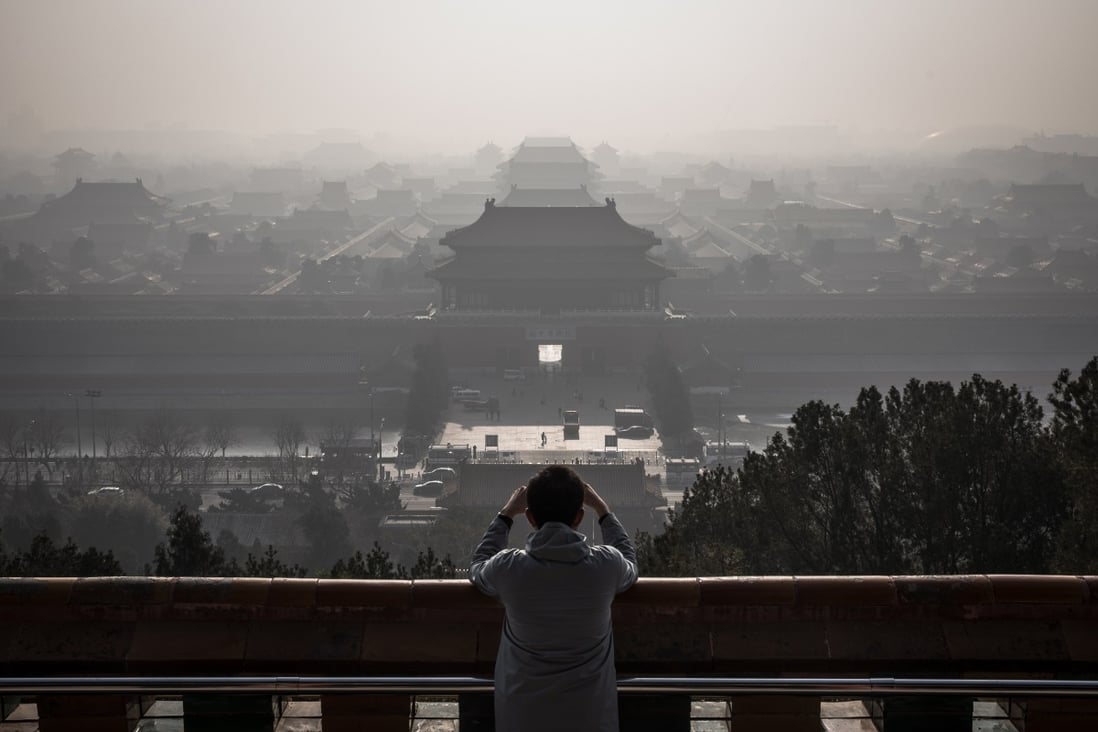 A man standing at a viewing area of Jingshan Park takes photos of the Forbidden City as a thick haze engulfs Beijing on December 9, 2019. China is hoping to establish itself as the new global leader in the fight against climate change, following the United States’ withdrawal from the Paris Agreement signed in 2015. Photo: EPA-EFE