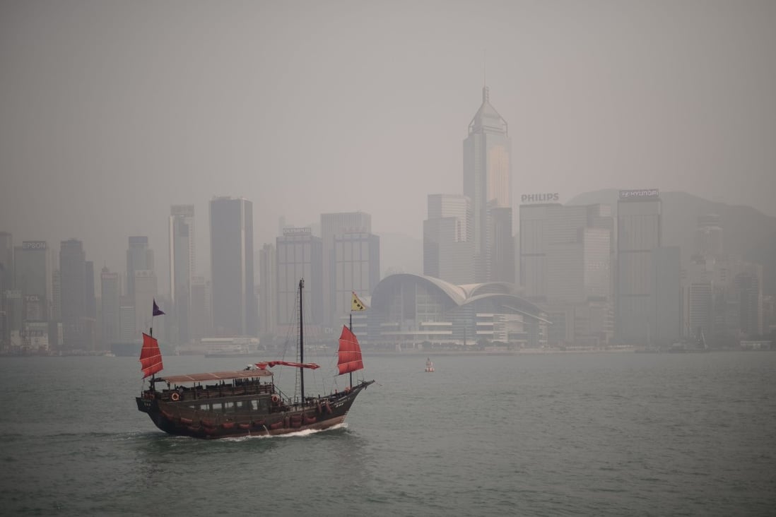 A junk sails down Hong Kong’s Victoria Harbour while the iconic skyline is shrouded in a dense blanket of smog. Hong Kong is among the world’s most exposed cities to threats of coastal flooding, but has struggled to meet its goals for curbing pollution and carbon emissions. Photo: AFP