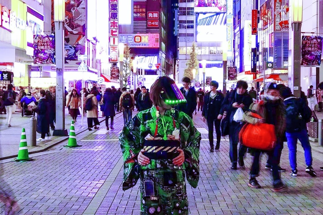 Cyber Okan in one of her kimonos on the streets of Akihabara in Tokyo. Instead of keeping it traditional, she adds LED and neon lights to it, as well as other cyberpunk elements.