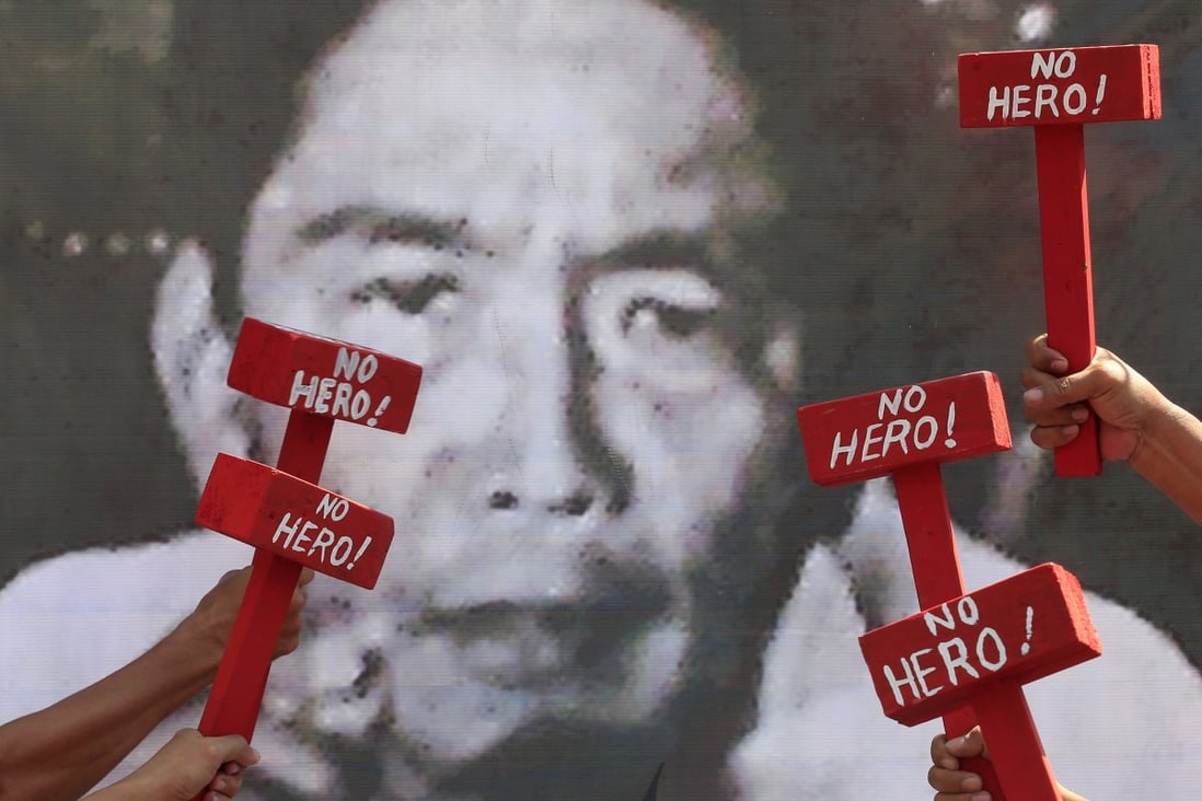 Protesters hold mock hammers with the words “No Hero” in front of a portrait of the late president Ferdinand Marcos as they denounce his burial at the Heroes' Cemetery in Manila in November 2016. Photo: Reuters