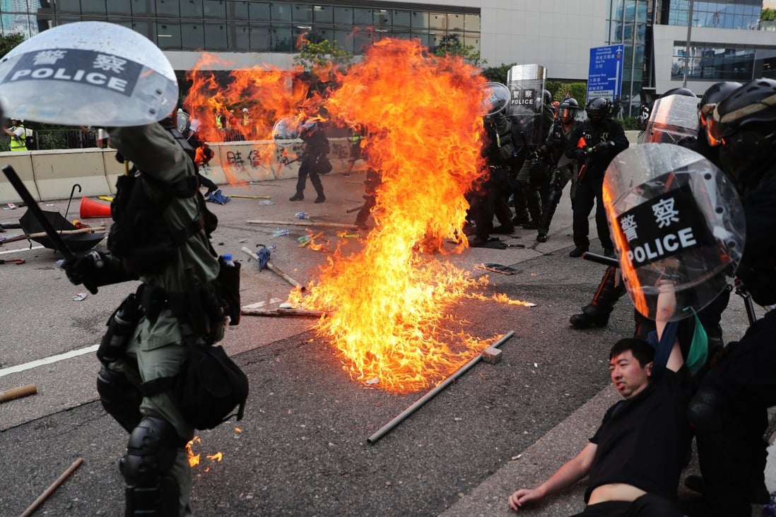 A petrol bomb lands near riot police, close to the Ngau Tau Kok police station as police officers arrest protesters on August 24, 2019. Photo: Sam Tsang