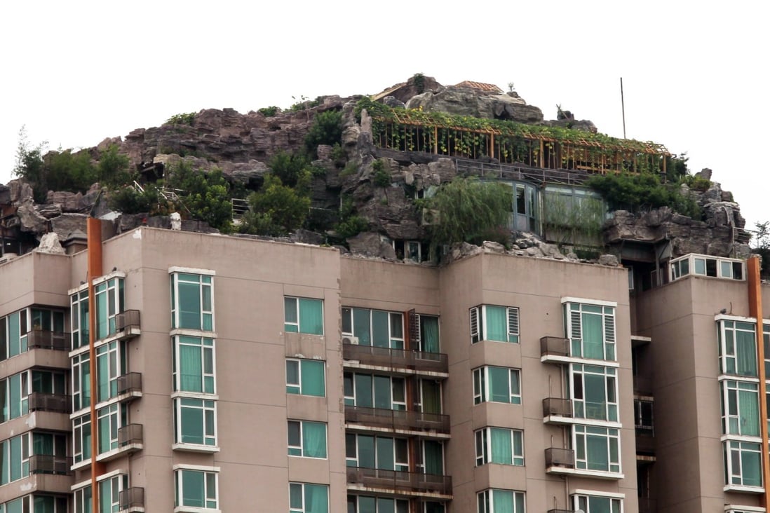 A 26-storey residential building in Beijing in 2013 on top of which the owner built a villa with a fake mountain and trees. Illegal structures are common throughout China and Hong Kong. Photo: Simon Song