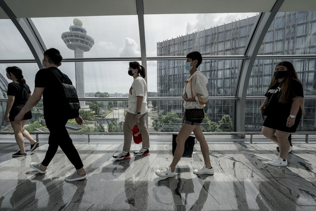 People walk along a link bridge connecting the terminal building to the Jewel Changi airport mall in Singapore. Singapore has tightened restrictions on arrivals from high-risk places, including Britain and New South Wales. Photo: EPA-EFE