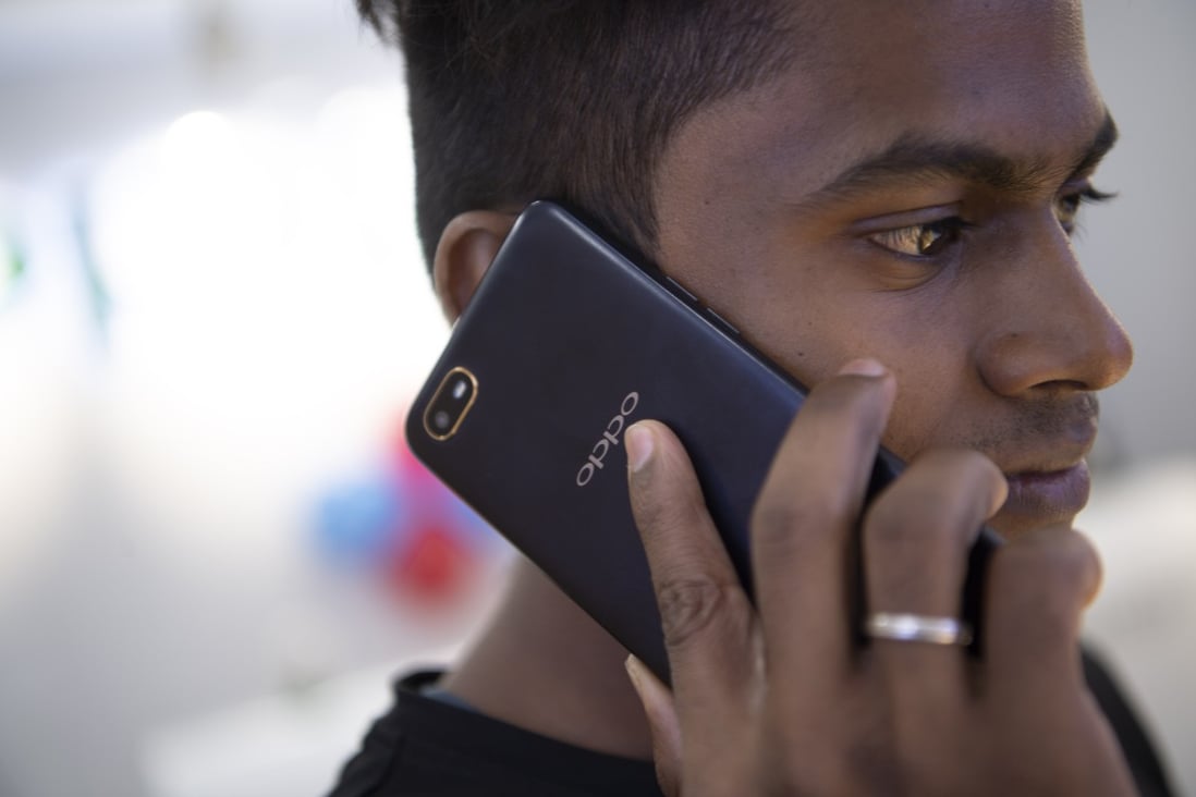 A man uses a phone with Chinese Oppo brand at a shopping centre in Chennai, India, October 8, 2019. Photo: Xinhua
