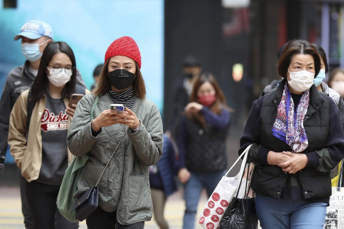 Residents wearing face masks bundle up against the cold in Hong Kong. The city reported 53 new Covid-19 cases on Wednesday, taking the total to 8,353. Photo: Xinhua