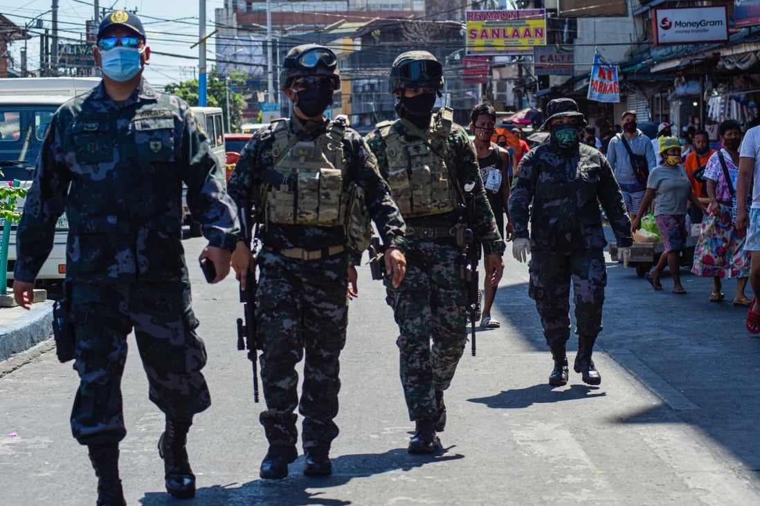 Policemen patrol a market in Manila. A bizarre prank has highlighted public anger and mistrust of the force. Photo: AFP