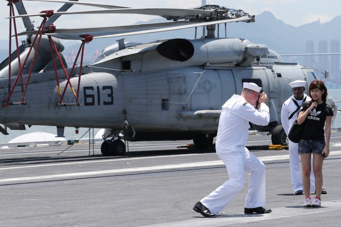 A sailor photographs a visitor on the deck of the USS George Washington during a 2012 stop in Hong Kong. Photo: Felix Wong