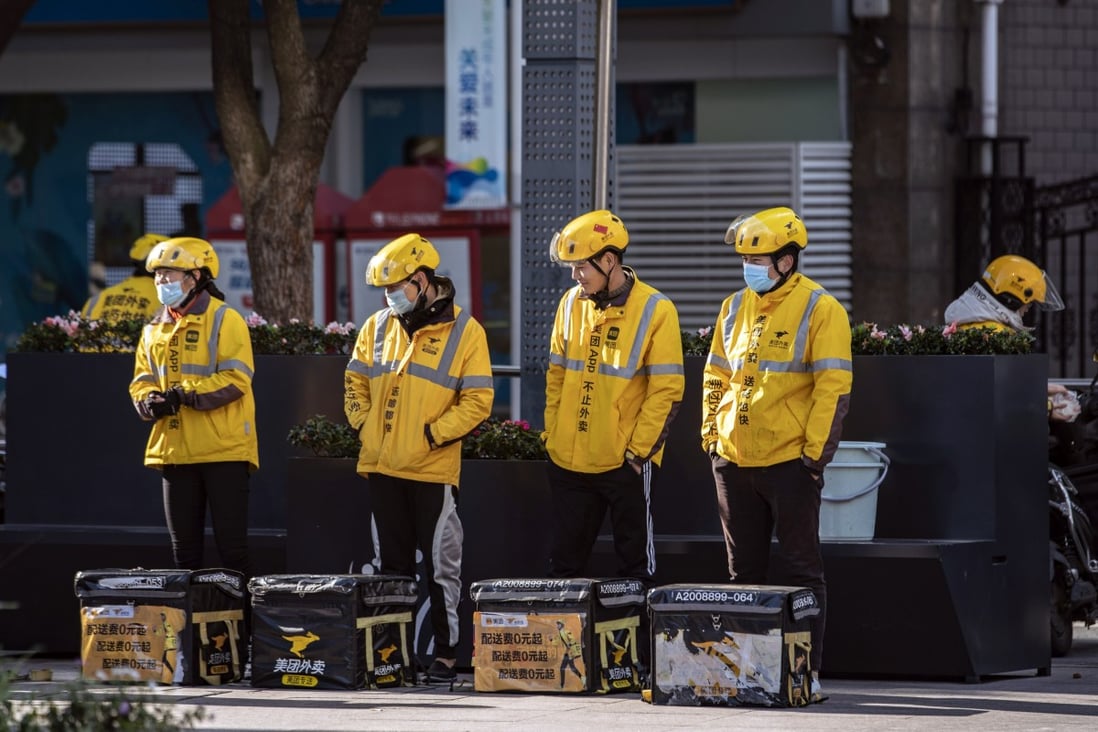 Food delivery couriers for Meituan stand with insulated bags during a morning briefing on a street in Shanghai on November 29, 2020. Photo: Bloomberg