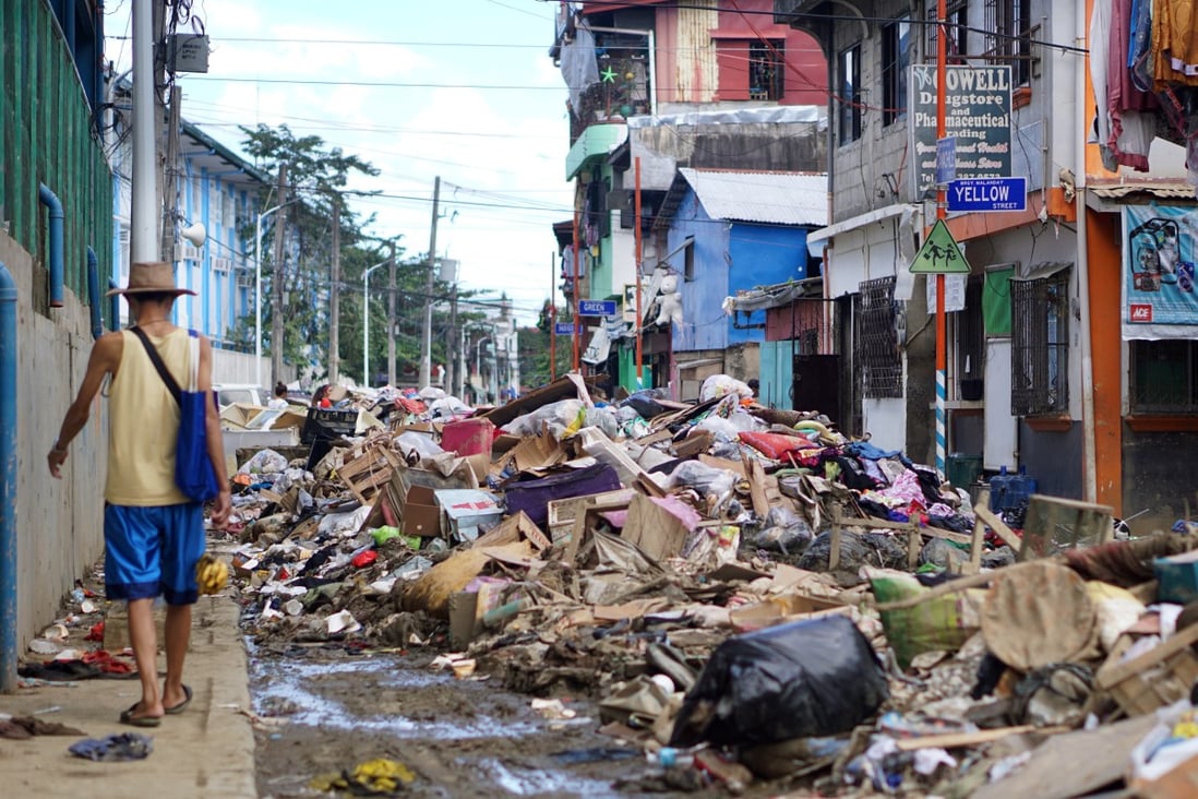 Rubbish is piled up in the middle of the street after floods in Barangay Malanday, Marikina City, the Philippines. An average of 20 typhoons a year now hit the country, with flooding devastating many towns and cities. Photo: AJ Bolando