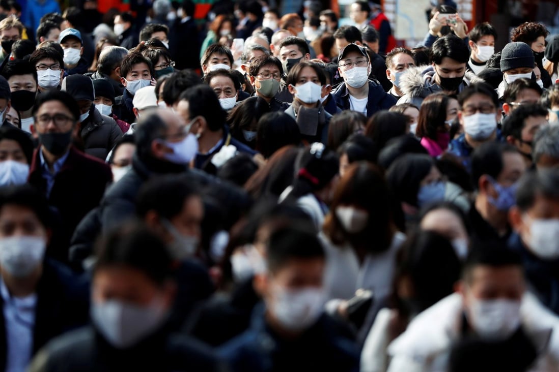 Visitors wearing face masks wait to offer prayers at a shrine in Tokyo on Monday. Japan saw a spike in coronavirus cases over the year-end period. Photo: Reuters
