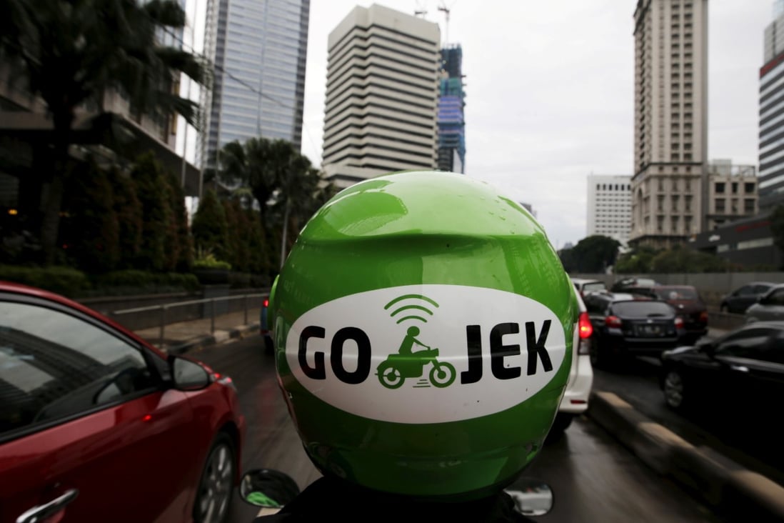 A Gojek driver rides his motorcycle through a business district street in Jakarta, Indonesia on June 9, 2015. Photo: Reuters
