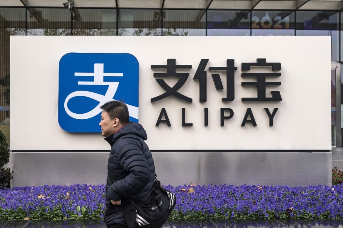 A pedestrian walks past an Alipay sign in Shanghai in December. Photo: Bloomberg