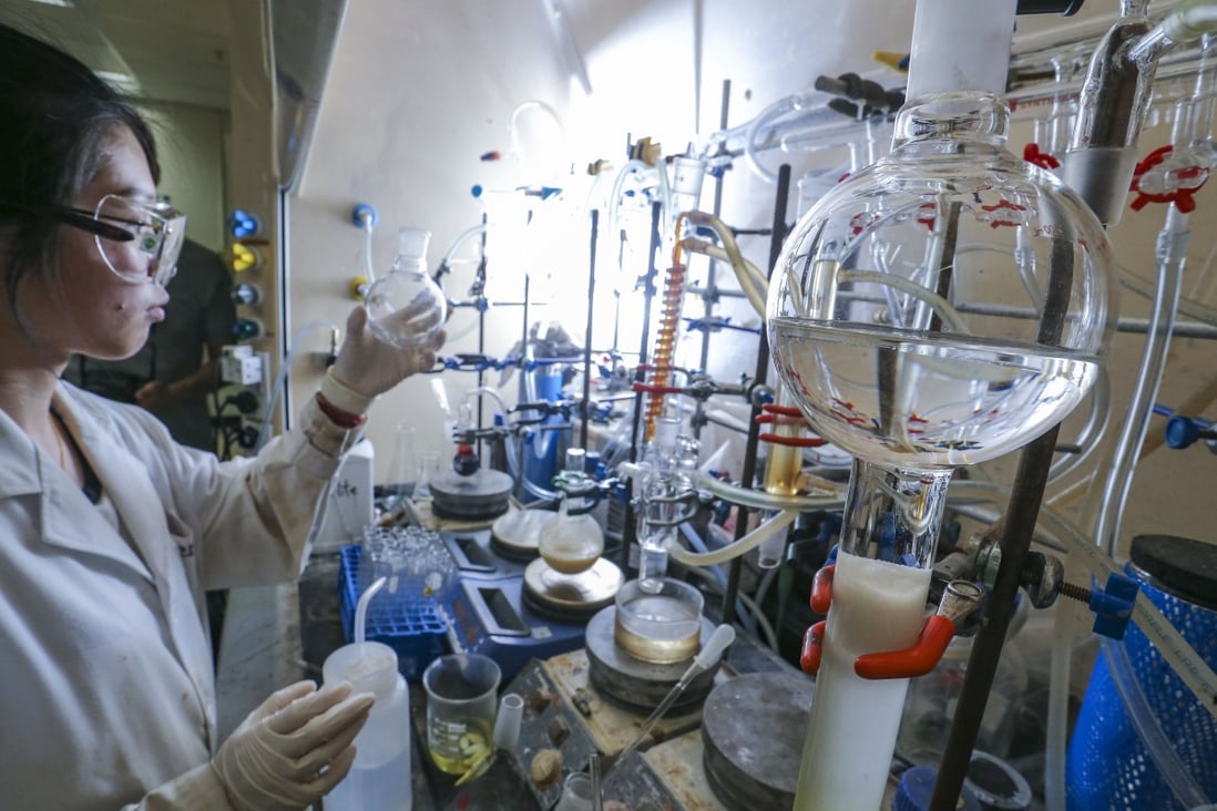 A researcher examines luminescent materials developed by the State Key Laboratory of Synthetic Chemistry at the University of Hong Kong in Pok Fu Lam. Photo: SCMP/Dickson Lee