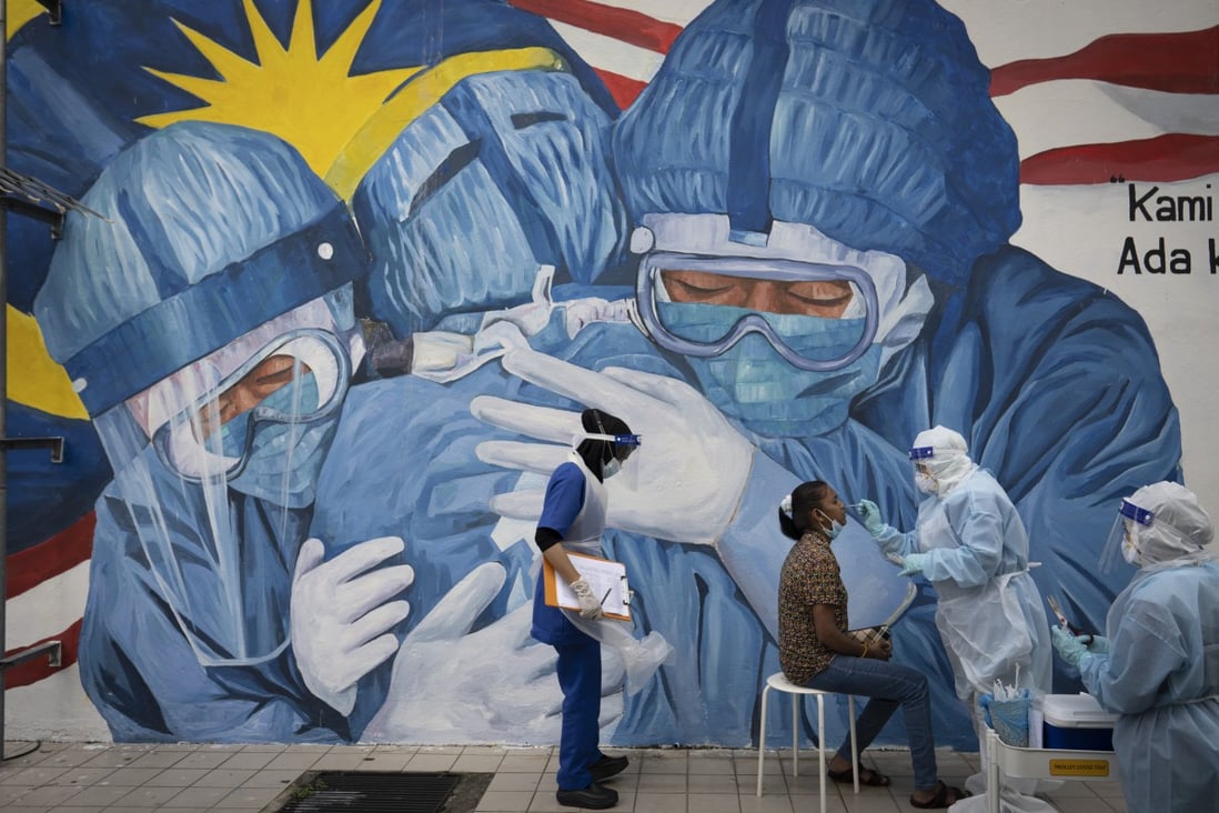 A doctor collects a sample for testing from a lady at a coronavirus screening in Shah Alam, Malaysia. Photo: AP