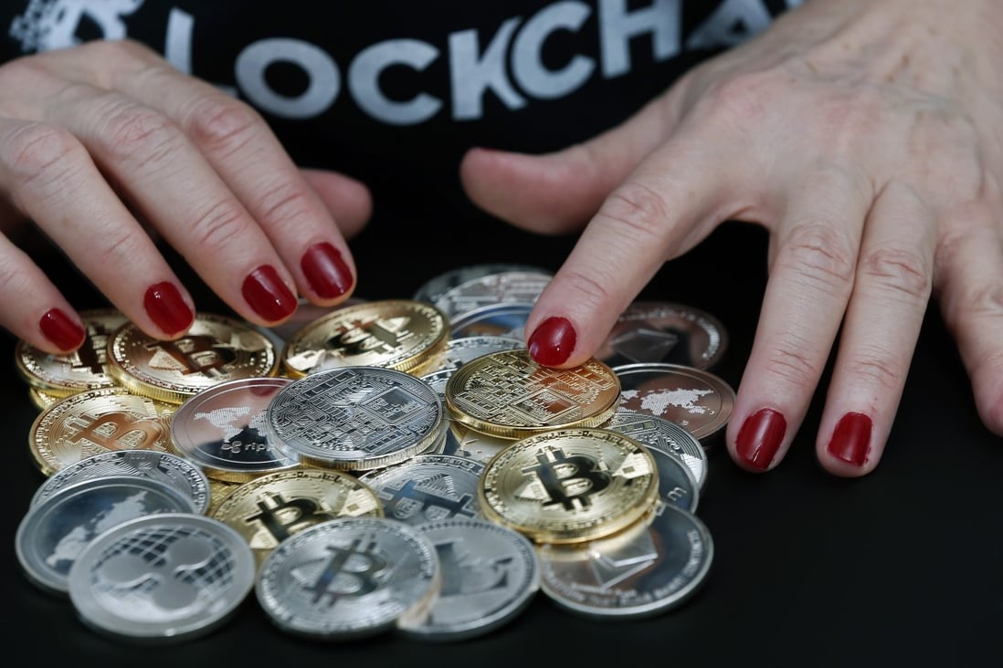 A woman shows different visual representations of cryptocurrencies, Ripple, Bitcoin, Litecoin and Ethereum on February 01, 2018 in Paris. Photo: Getty Images