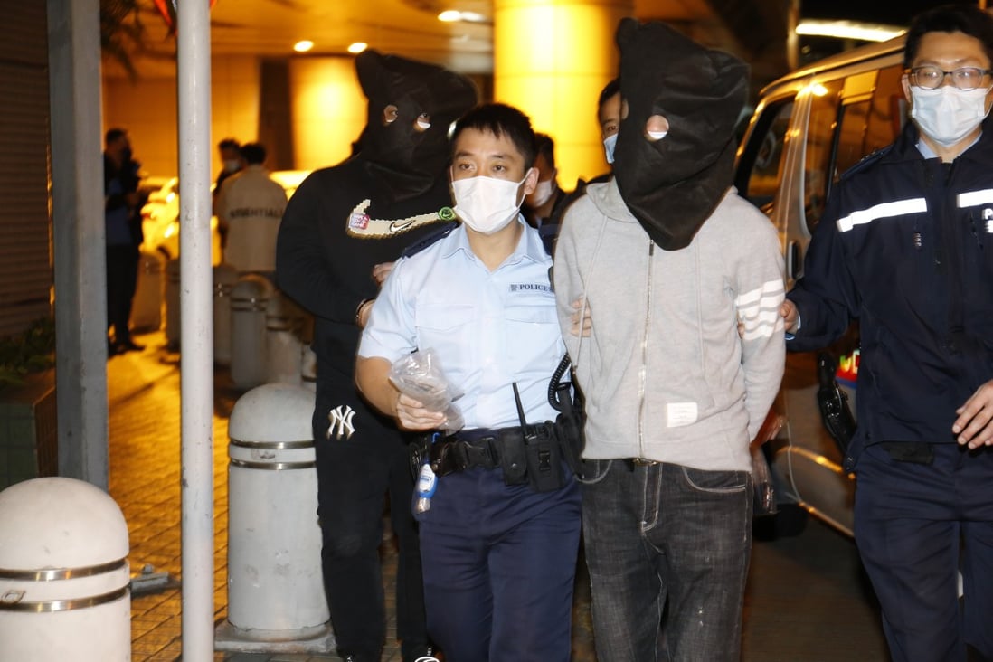 Two alleged triad members are led away by police after their arrest in the early hours of Thursday in Kowloon. Photo: Handout