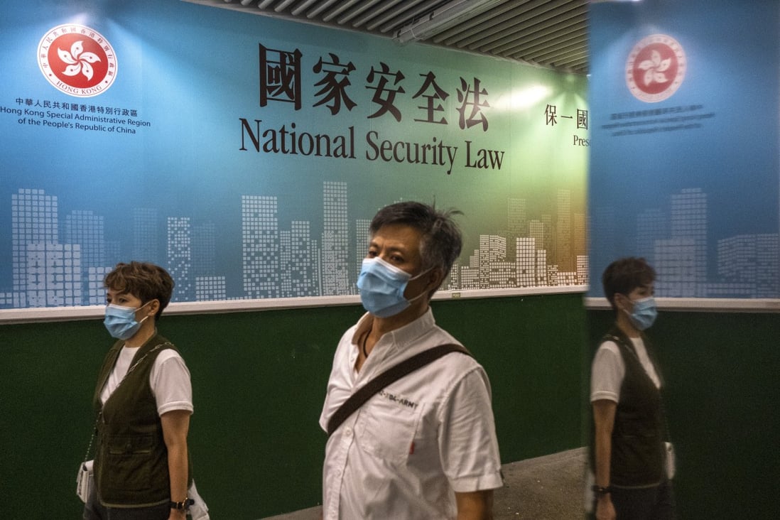People walk past a large banner promoting the national security law in Tsim Sha Tsui. Photo: Sun Yeung