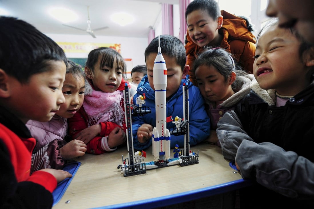 Children look at a model of the Long March rocket during an aerospace education lesson at a primary school in Yunyang county in southwestern China’s Chongqing province on December 16, 2020. Photo: Agence France-Presse