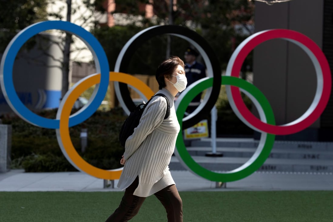 A woman walks past the Olympic rings in front of the Japan Olympics Museum, in Tokyo, in March 2020. Photo: Reuters