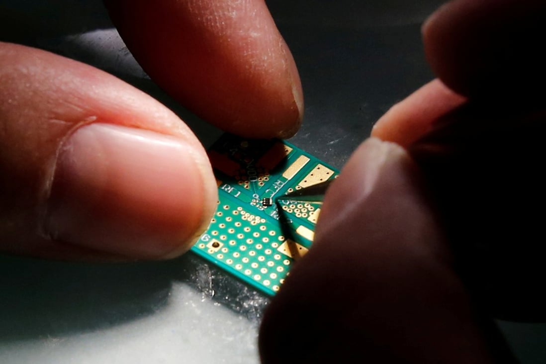 A researcher plants a chip on an interface board at Tsinghua Unigroup’s research centre in Beijing. Photo: Reuters