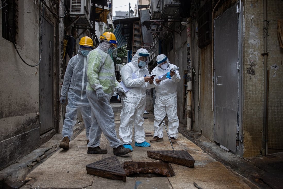 Workers check the sewage of an old tenement building as part of an effort to track the spread of the coronavirus in Jordan, Hong Kong. Photo: EPA-EFE