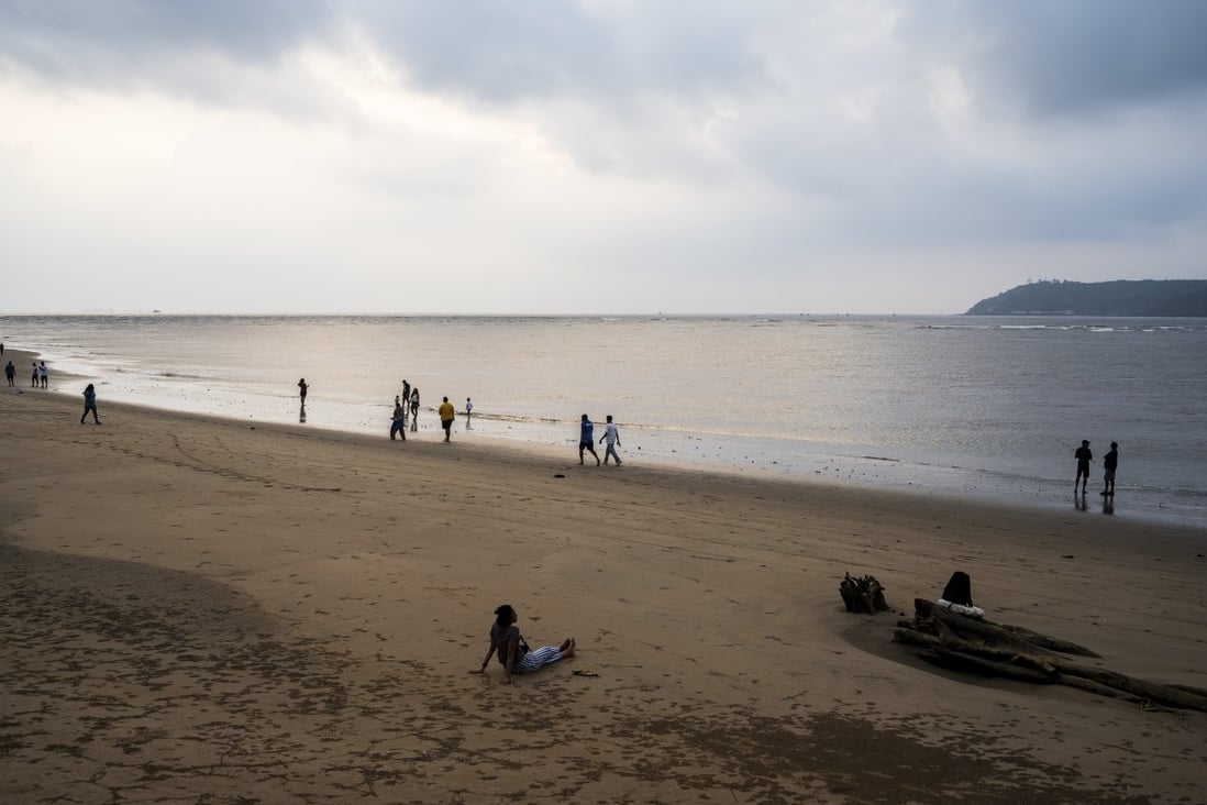 Local people walk along a beach in Goa, India. The popular tourist destination has been devastated by the Covid-19 pandemic that has destroyed Goa’s booming tourist industry. Photo: AFP