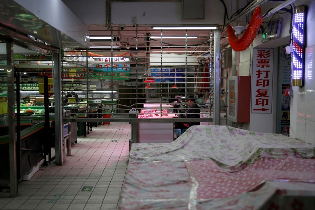 A man sits at a meat-market stall in a partially closed shopping centre in Beijing amid the coronavirus outbreak last year. Photo: Reuters