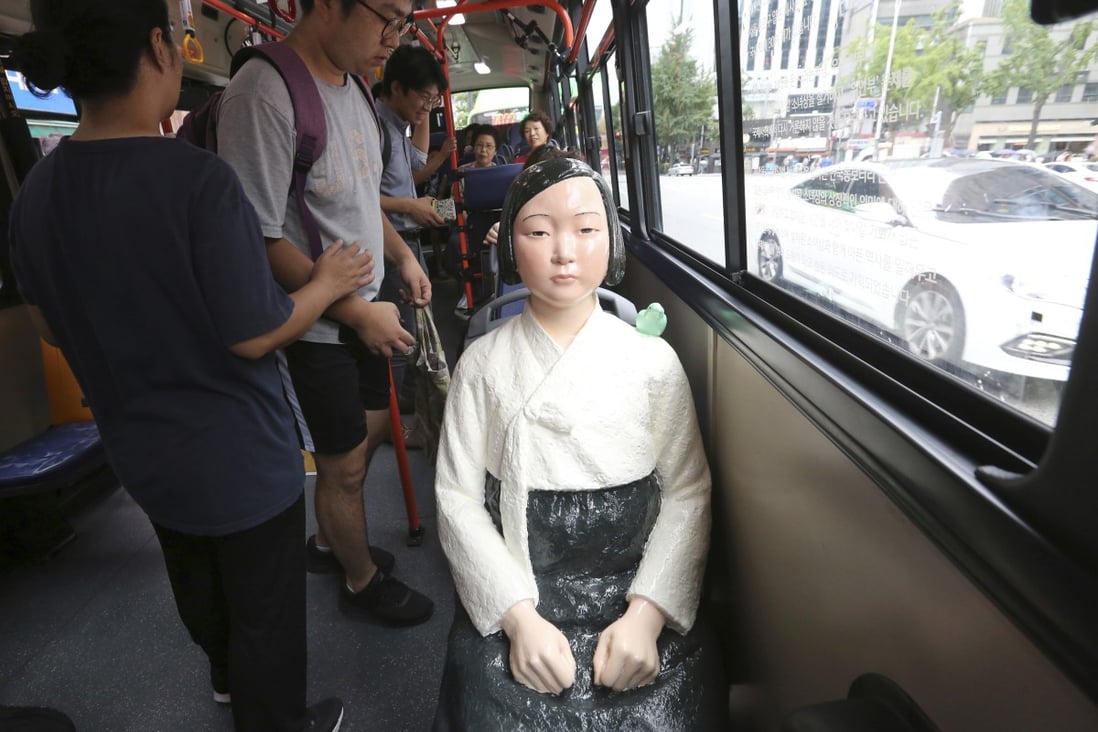 A comfort woman statue is placed on a chair of a bus to mark the 5th International Memorial Day for Comfort Women in Seoul, South Korea. Photo: AP