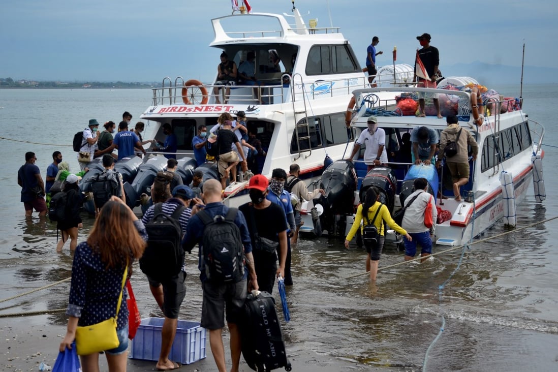 Tourists preparing to board a fast boat from Sanur beach, on the Indonesian resort island of Bali, this month. Some visitors obtain visas under false pretences and breach their conditions by working while there, as the recent expulsions of American Kristen Gray and Russian Sergei Kosenko have revealed. Photo: AFP