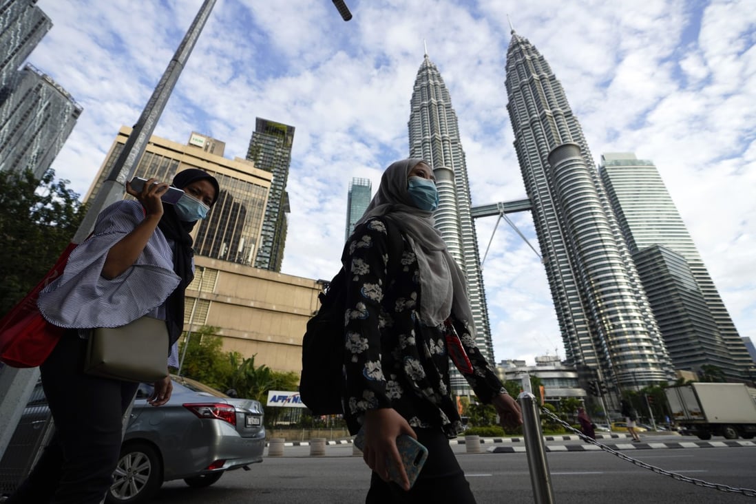 Women wearing face masks walk in downtown Kuala Lumpur. Photo: AP