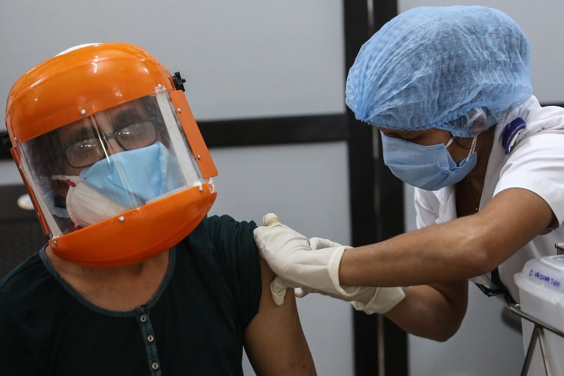A woman wearing a face mask and shield receives her first shot of a coronavirus vaccine in India, despite widespread distrust in the country about the inoculation drive. Photo: EPA-EFE