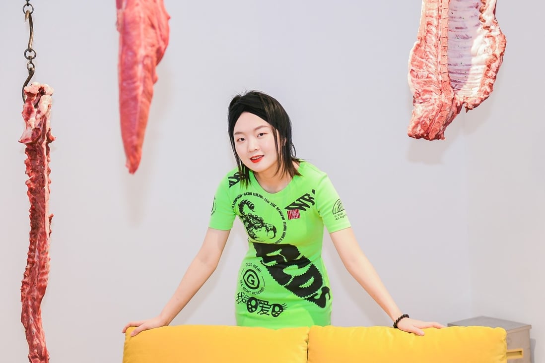 Macalline Art Centre founder Che Xuanqiao poses amid an exhibition she oversaw in Shanghai of furniture from The Shouter, a high-end brand she co-founded, juxtaposed with hunks of raw pork and beef.