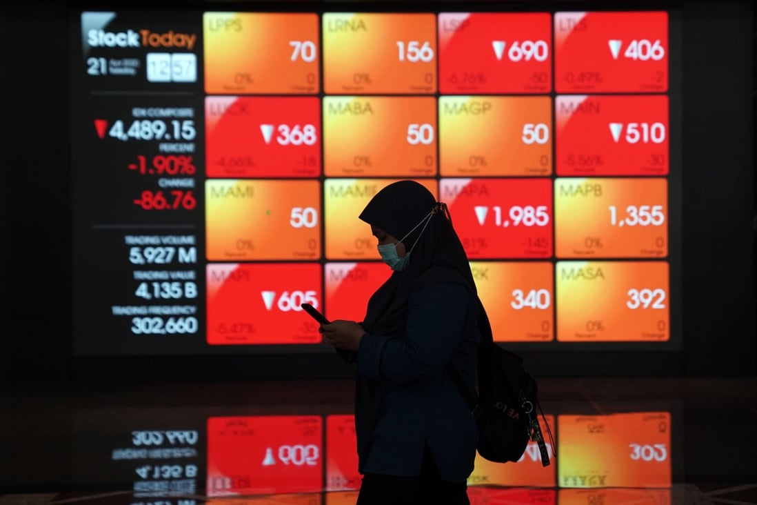 A woman walks past an electronic board displaying stock prices in the lobby of the Indonesia Stock Exchange in Jakarta. Photo: Bloomberg