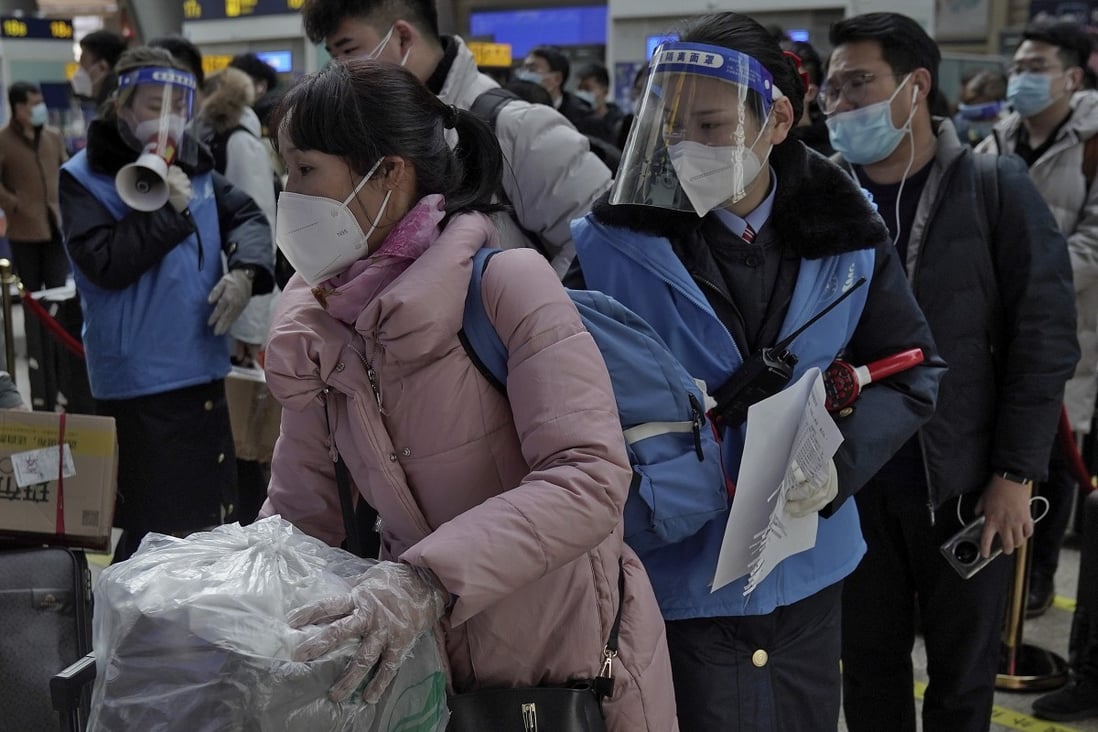 Staff wearing face masks and shields direct rail passengers in Beijing on Thursday, although the number travelling was said to be smaller than in previous years. Photo: AP