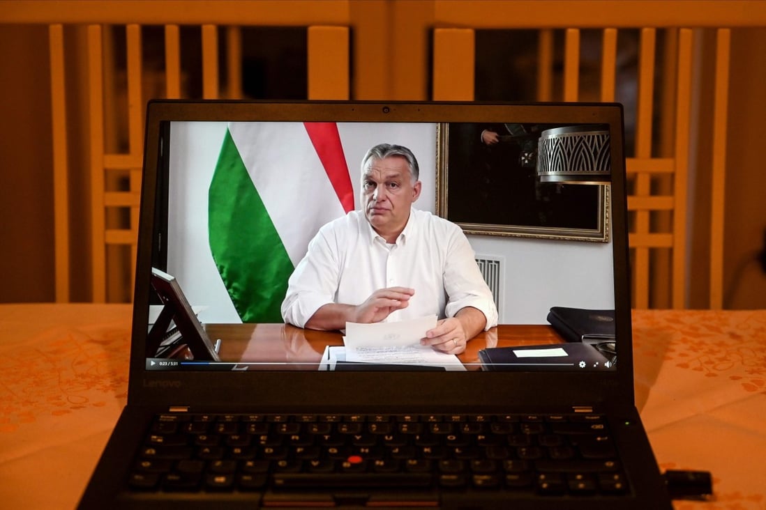 Hungarian Prime Minister Viktor Orban is seen on a laptop screen during a coronavirus announcement. Photo: AFP