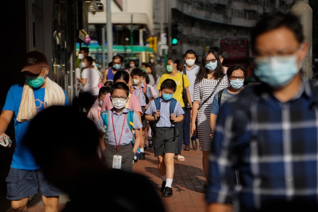 Schoolchildren and other pedestrians walk on a pavement in Hong Kong in July last year. Hong Kong schools have been closed on and off for a full year now. Photo: Bloomberg
