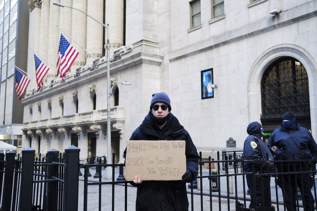 An activist, standing in front of the New York Stock Exchange on January 28, holds a sign calling for an increase in the capital gains tax. Photo: EPA-EFE