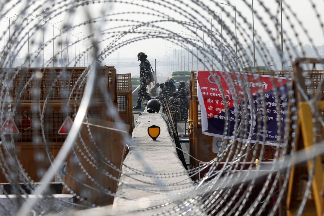 Indian security personnel are seen on Tuesday through barbed wire placed as farmers protest at the Ghazipur Border near New Delhi. Photo: EPA