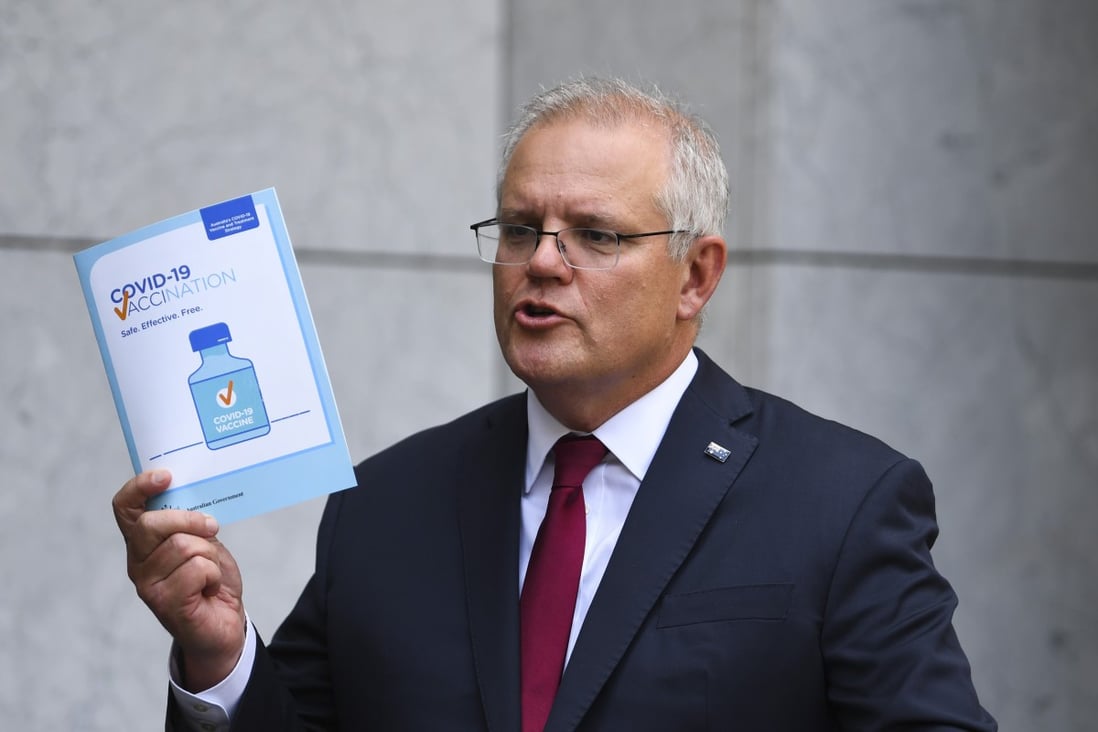 Australian Prime Minister Scott Morrison holds up a Covid-19 vaccination leaflet as he speaks to the at Parliament House in Canberra on Thursday. Photo: EPA