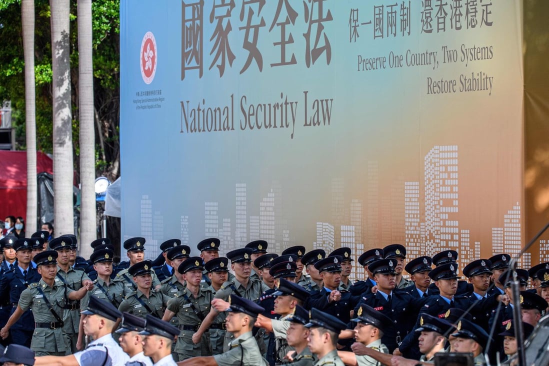 Officers march in front of a banner of the national security law at a ceremony last year. Photo: AFP