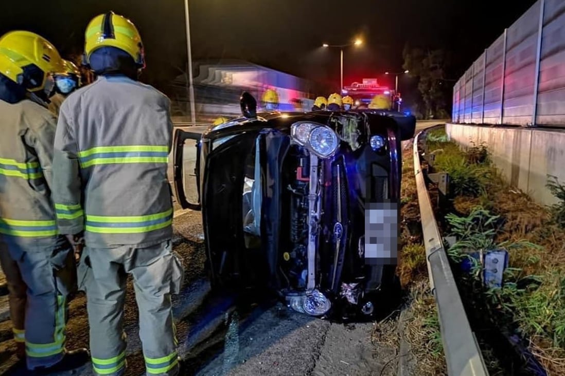 Emergency personnel at the scene after the woman’s car flipped to one side. Photo: Facebook