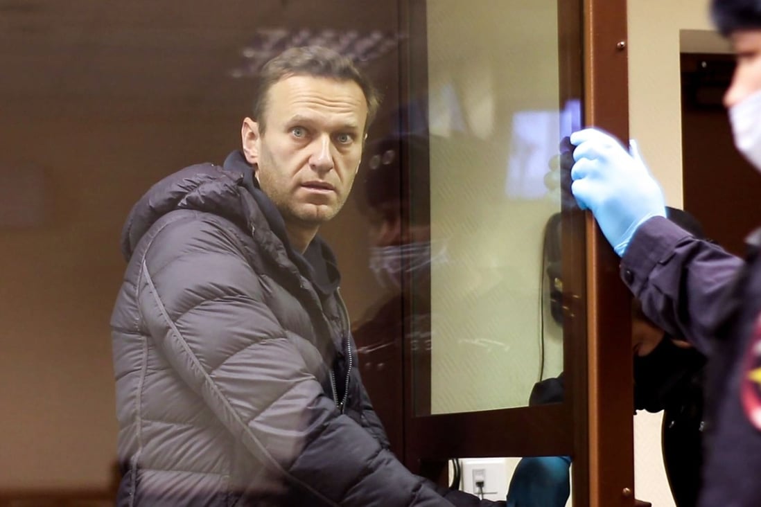 Russian opposition leader Alexei Navalny looks from inside a glass cell during a court hearing in Moscow. Photo: Handout via AFP
