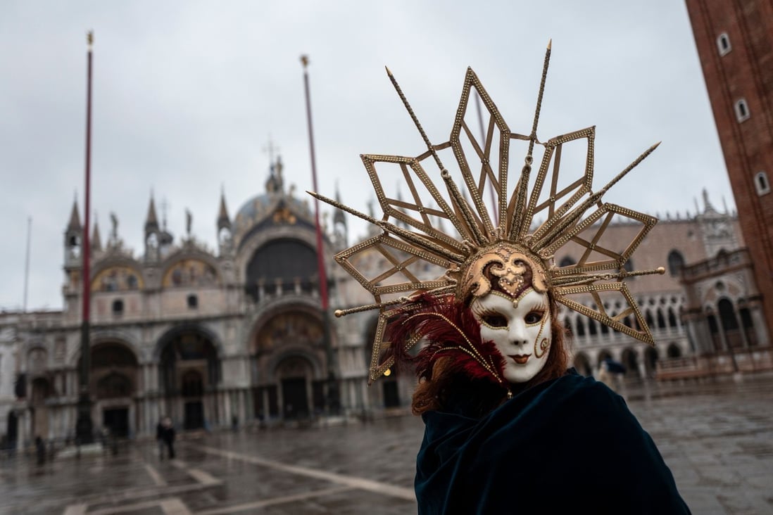 A Venetian wearing a carnival mask and costume at St Mark's square in Venice on Sunday. Photo: AFP