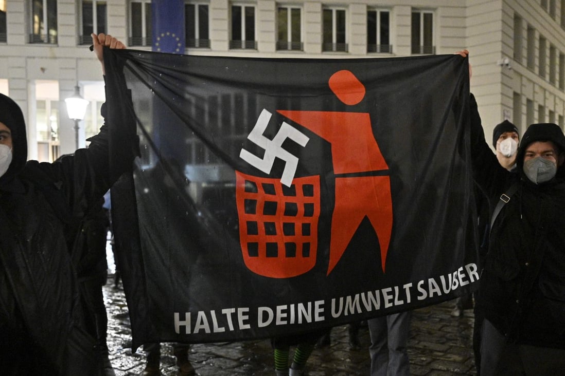 Demonstrators hold a banner that depicts a swastika being thrown in the bin during a protest in Vienna in January. Photo: AFP