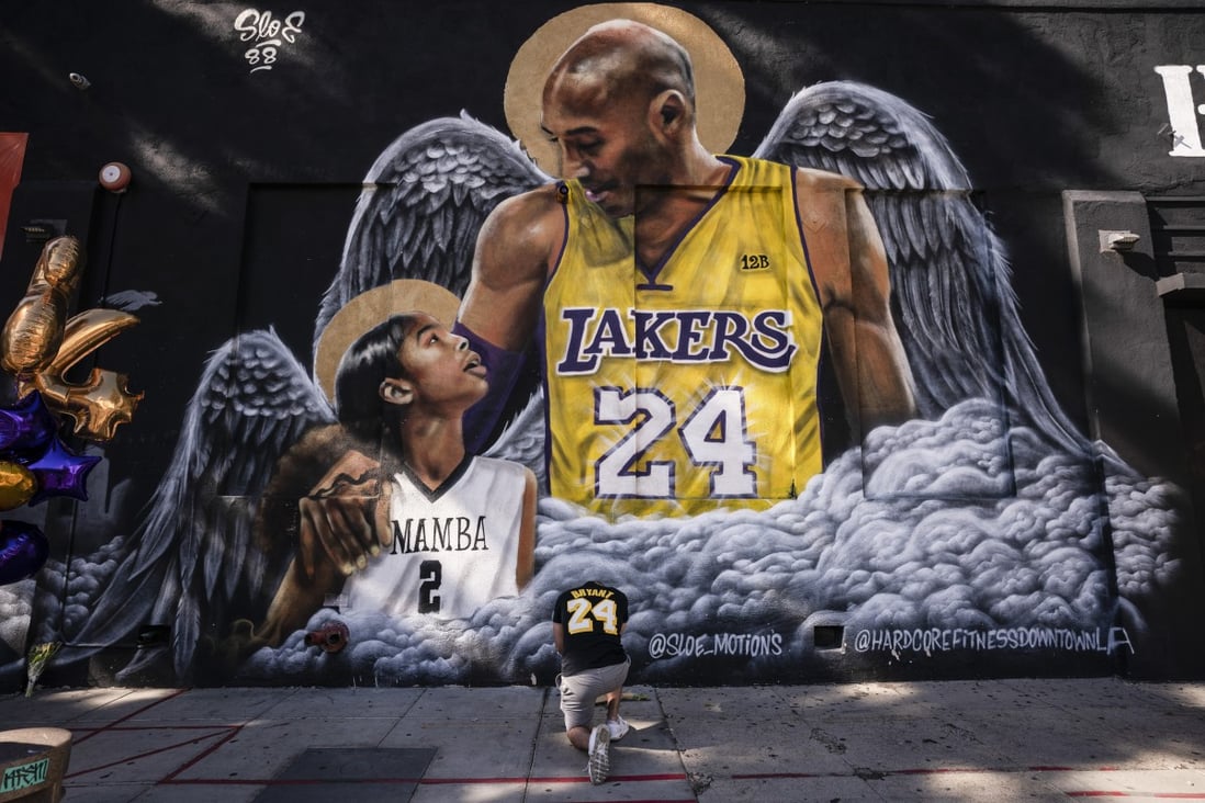 A fan pays respects to basketball legend Kobe Bryant and his daughter, Gianna, in front of a mural painted by artist Louie Sloe Palsino in Los Angeles in January. Photo: AP