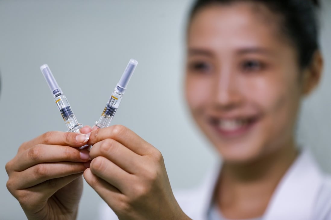 A Sinovac staff member displays two doses of its Covid-19 vaccine. Photo: Xinhua