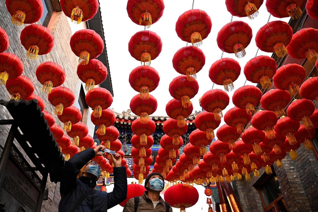 People walk under traditional Chinese lanterns along an alley in Beijing as the nation prepares to usher in the Year of the Ox on Friday. Photo: AFP
